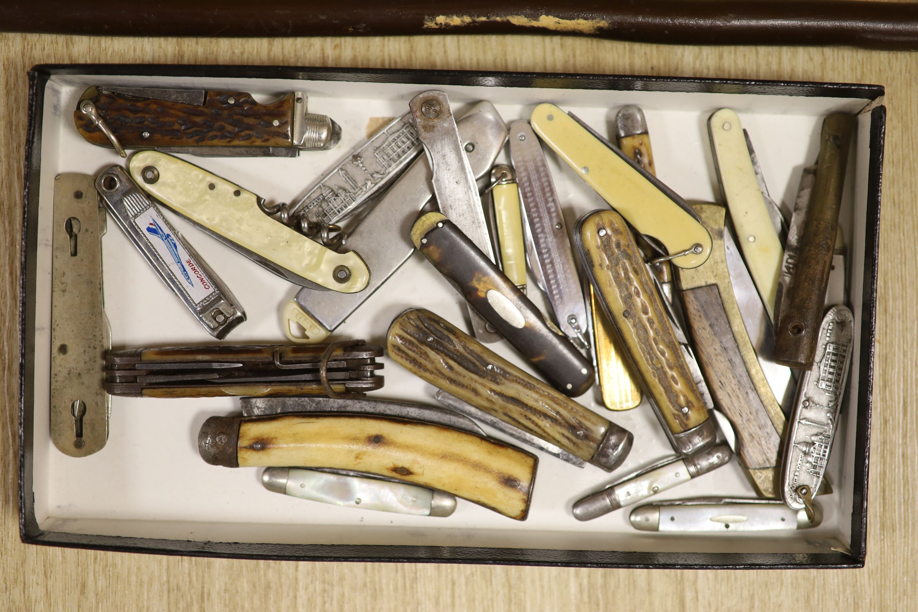 A walking cane with carved bird grip, and a collection of pen knives